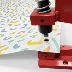 A PVC banner being hole punched with eyelet machine