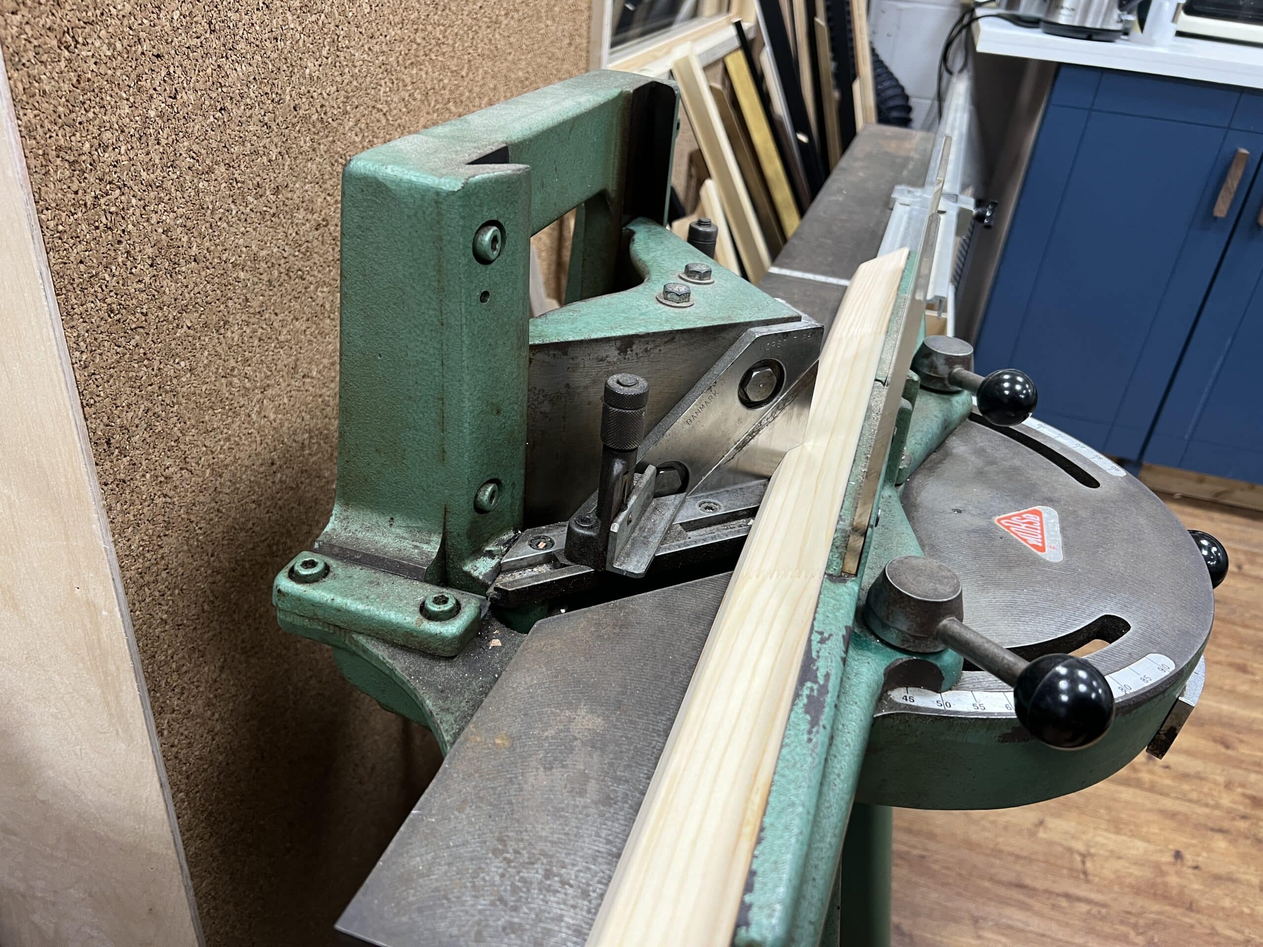 A swiss made morso guillotine cutting a mitre in a frame moulding